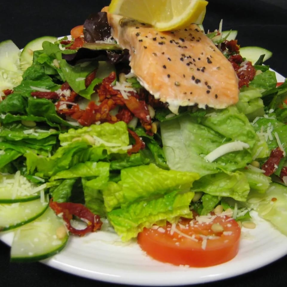 Angelo's West Italian salmon salad with lettuce, cucumbers, tomatoes, sun-dried tomatoes, and parmesan.
